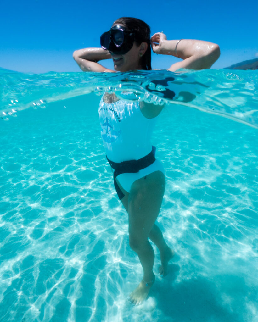 girl in water, half half shot, half ocean half sky Moorea French Polynesia