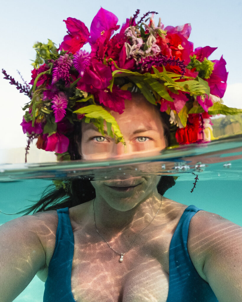 Girl with flower crown, half underwater half above water Moorea French Polynesia