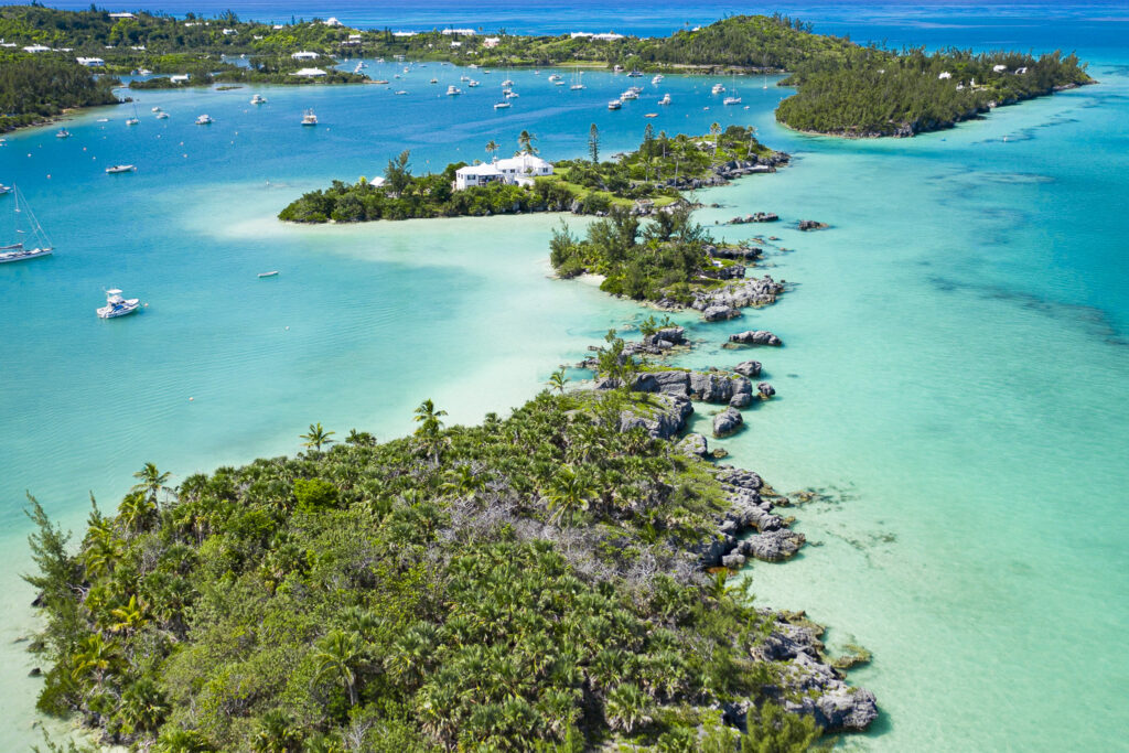 Drone image of Bermuda, bright, glowing blue and turquoise water with multiple islands full of lush green trees
