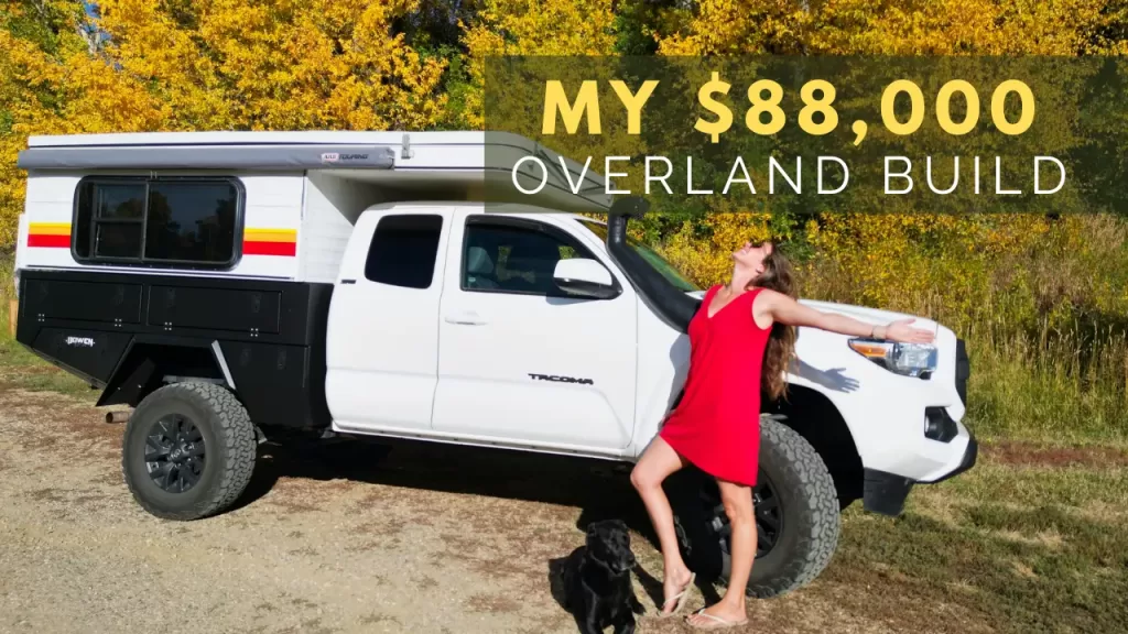 Girl in red dress with black dog in front of a 2023 Toyota Tacoma with a camera and black bed replacement